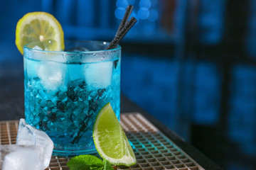 Glass of Blue Lagoon cocktail on table in bar