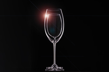Empty wine glasses on black background, glassware for drinks. Contours and light glare, horizontal arrangement