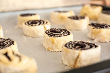 Raw poppy buns on baking sheet, closeup