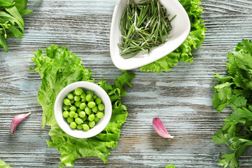 Fresh herbs with vegetables on wooden background