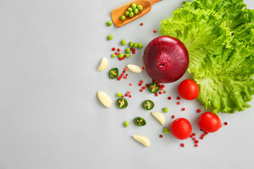 Fresh vegetables and spices on grey background