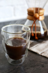 Glass of hot coffee on table
