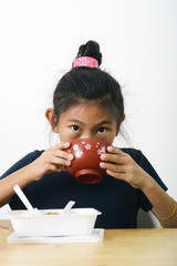 Asian girl eating spaghetti food box and soup bowl from convenient store, modern lifestyle concept.