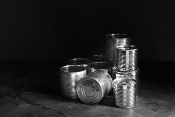 Tin cans with food on dark background