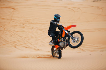 Riding on one wheel motorcycle at the desert