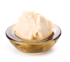 Bowl with shea butter on white background
