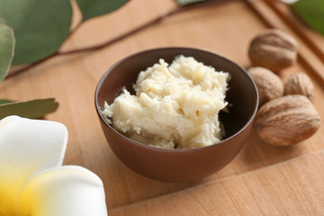Bowl with shea butter on wooden board