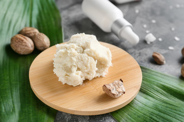 Board with shea butter on grey background
