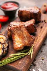 Board with tasty grilled meat on table