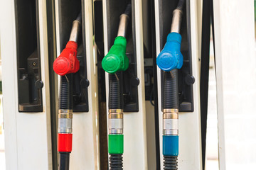 Close up fuel nozzle in oil dispenser with gasoline and diesel in service gas station. Pattern...