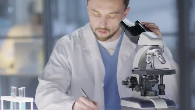 Tilting close up shot of Caucasian male lab assistant