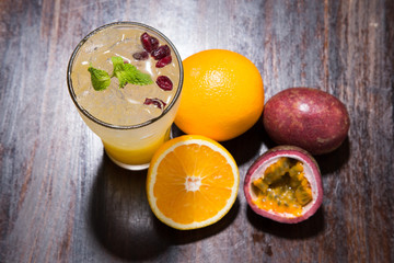 tropical cocktail with passion fruit, orange and mint on a dark background 