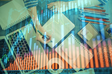 Financial chart drawn over hands taking notes background. Concept of research. Double exposure