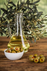 Olive oil, olive tree and green olives, bottles of olive oil