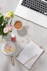 Office desk with laptop, pink lisiathus bouquet, coffee mug, diary on white background. Flat lay. Top view. Fashion or freelance concept with copy space