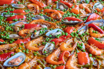 Spanish seafood paella in fry pan with mussels, shrimps and vegetables. Seafood paella background, closeup, traditional spanish rice dish