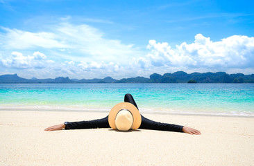Fototapeta na wymiar Woman relaxing on beach, lying down tropical beach, ocean view, Poda Island, Krabi, Thailand.