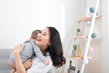 happy family at home. Mother holding baby daughter in living room in cozy weekend morning