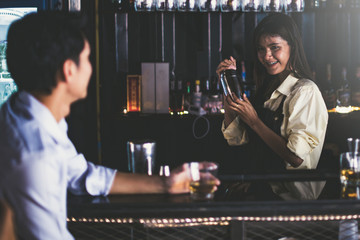 Beautiful girls bartender mix drinks and serve them to customers
