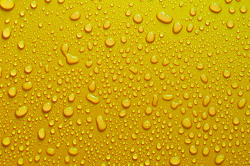 water drop texture close-up on yellow matte background.
