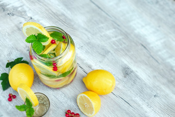 Homemade lemonade with fresh lemons, mint and cranberries. A can of lemonade on a white wooden background. The concept of fresh lemonade, cold juice, heat
