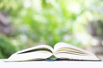 Open Book with Green Blurred Nature Background.