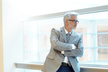 Mature business man looking out office window