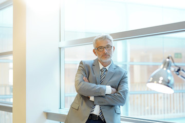 Fototapeta premium Mature business man looking out office window