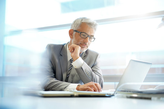 Stylish businessman working at desk in contemporary office