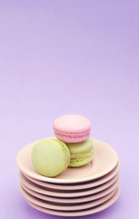Three macaroons on a stack of beige saucers.