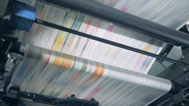 Fake news concept. Printing press is issuing dyed paper piece