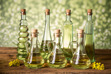 Seeds and rape flowers in bottles and carafes with rapeseed oil
