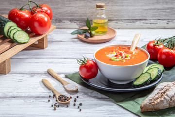 Gazpacho. Traditional Spanish tomato soup with fresh tomatoes, fresh cucumber and olive oil, on white wood base