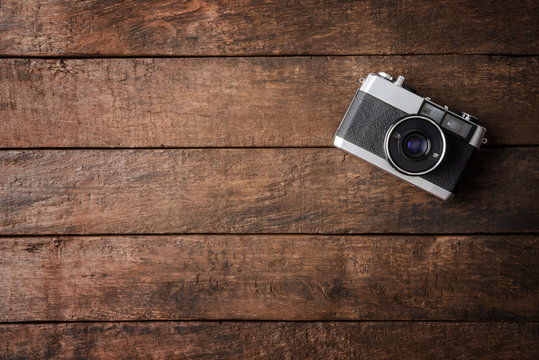 Old photo camera on wooden background