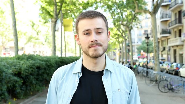 Front view of a happy man saying yes at camera in the street