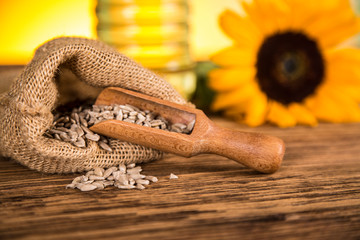 Sunflower oil in a bottle and sunflower flowers and sunflower seeds in a sack