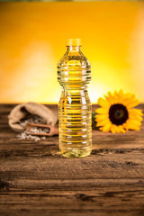 Sunflower oil in a bottle and sunflower flowers and sunflower seeds in a sack