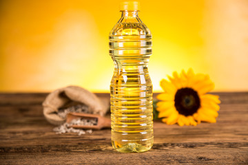 Sunflower oil in a bottle and sunflower flowers and sunflower seeds in a sack
