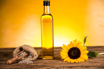 Sunflower oil in a bottle and sunflower flowers and sunflower seeds in a sack