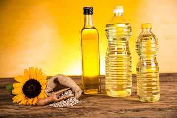 Sunflower oil in a bottle and sunflower flowers and sunflower seeds in a sack
