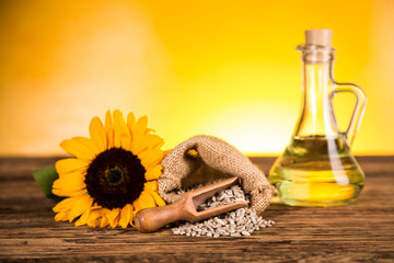 Sunflower oil in a bottle and sunflower flowers and sunflower seeds in a sack