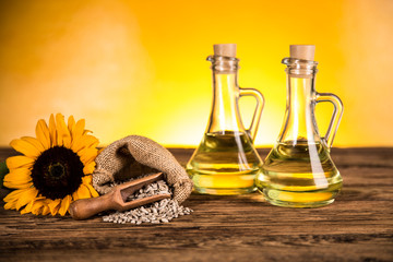 Sunflower oil in a bottle and sunflower flowers and sunflower seeds in a sack