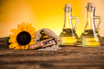 Sunflower oil in a bottle and sunflower flowers and sunflower seeds in a sack