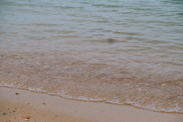 Beach top view with wave foam. Stock photo image of blue color of ocean water, sea surface. Soft blue ocean wave on sandy beach, turquoise waves, clear water surface texture. Nature background