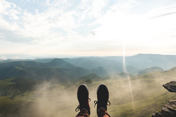 Feet Selfie sport shoes Traveler relaxing on cliff mountains clouds outdoor with aerial view...