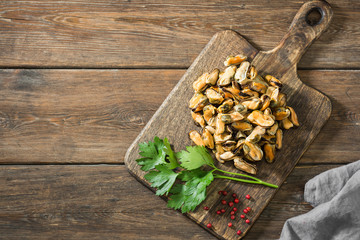 Fototapeta premium Mussel meat on a wooden Board on a wooden table. Rustic style