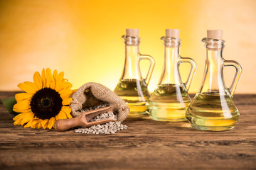 Sunflower oil in a bottle and sunflower flowers and sunflower seeds in a sack