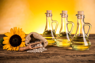 Sunflower oil in a bottle and sunflower flowers and sunflower seeds in a sack