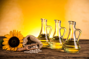 Sunflower oil in a bottle and sunflower flowers and sunflower seeds in a sack