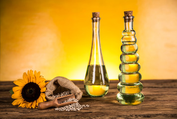 Sunflower oil in a bottle and sunflower flowers and sunflower seeds in a sack